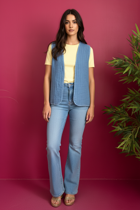 Gilet Matelassé Bleu porté pose décontractée fond framboise avec verdure
